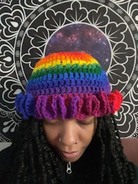 a woman wearing a rainbow crocheted hat