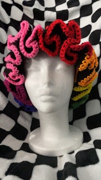 a mannequin wearing a crocheted rainbow hat