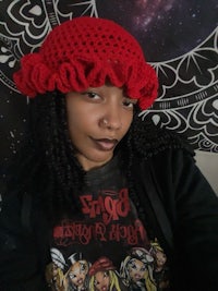 a woman wearing a red crocheted hat